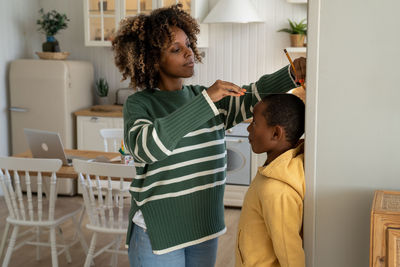 Side view of mother and daughter at home