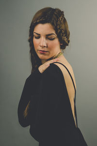 Portrait of young woman standing against wall