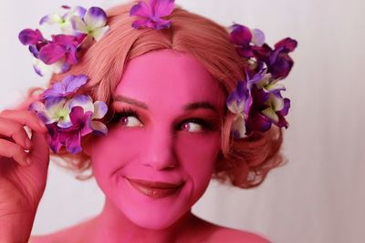 Close-up portrait of woman with pink flower