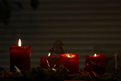 Close-up of illuminated candles and with christmas decorations at home