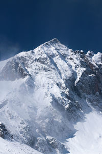 Scenic view of snowcapped mountains against clear blue sky
