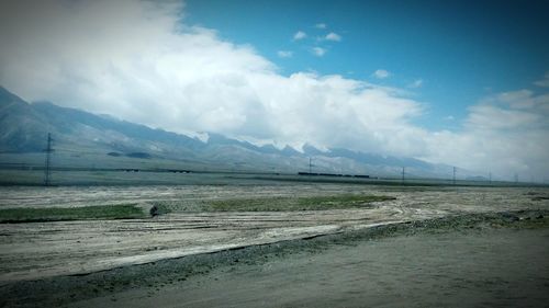 Scenic view of mountains against cloudy sky