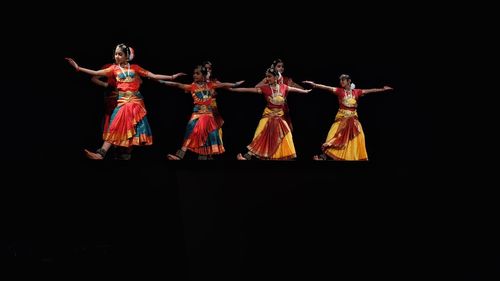 People dancing against black background