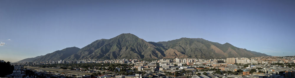 Panoramic view of town against clear blue sky