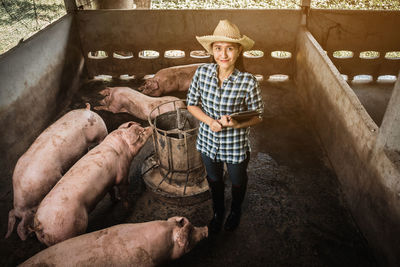 High angle portrait of female veterinarian smiling while standing in shed