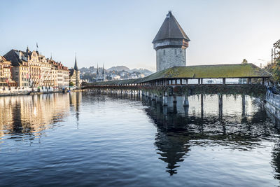 Luzern is reflected on the river on a sunny day with the chapel bridge