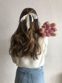 Rear view of woman standing against wall