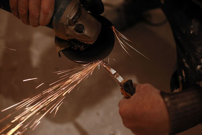 Cropped hand of manual worker using grinder