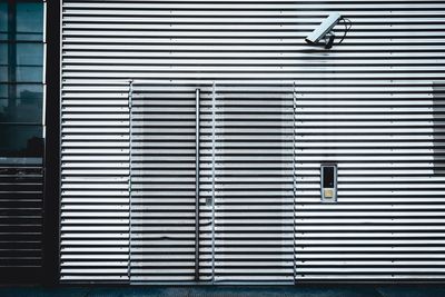 Security camera on corrugated building wall