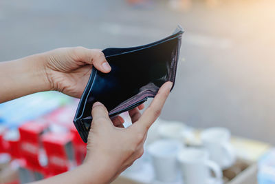 Close-up of woman holding empty wallet outdoors