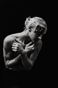 Low angle view of young man against black background