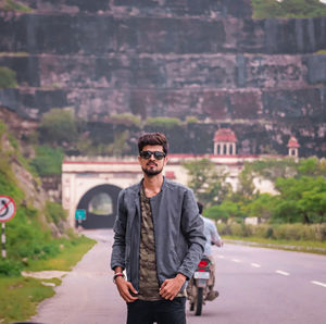 Portrait of young man standing on road