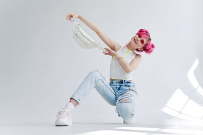 Full length of woman with dyed hair against white background