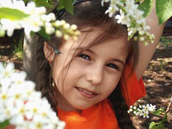 Portrait of cute girl with a blossoming cherry tree