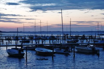 Boats in harbor at sunset