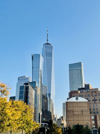 Modern buildings in city against clear blue sky