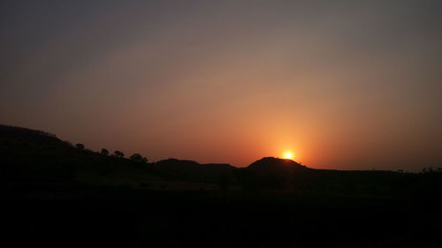 Scenic view of silhouette mountains against sky at sunset