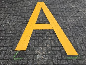 High angle view of alphabet on pavement