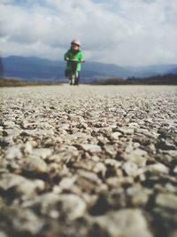 Surface level view of child with bicycle on road