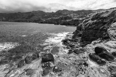 Scenic view of rocks in sea against sky