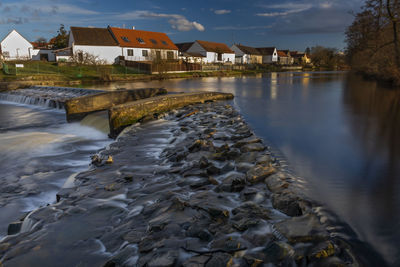 Scenic view of lake by buildings against sky