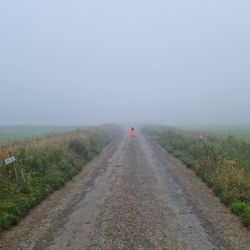 Road passing through landscape against sky