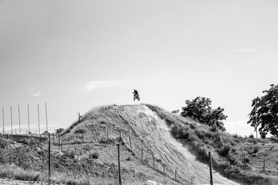 Motocross rider riding motorcycle against sky