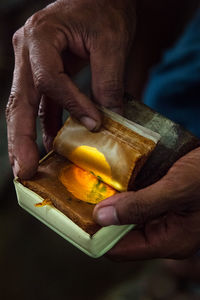 Cropped hands of man holding old book