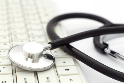 Close-up of stethoscope with computer keyboard on table