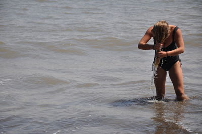 Full length of shirtless man standing on beach