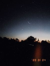 Silhouette trees against sky at night