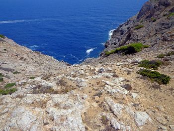 High angle view of rocks on sea shore