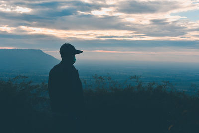 Silhouette man looking at sunset