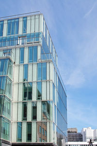 Low angle view of modern building against blue sky