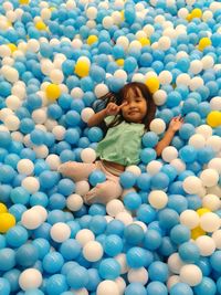 High angle portrait of girl amidst colorful ball pool