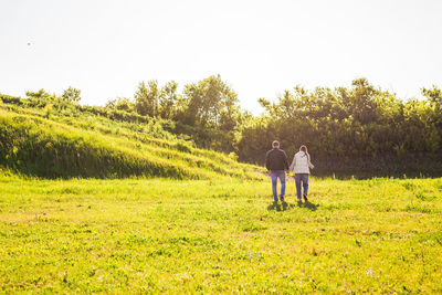 Man and woman on field against sky