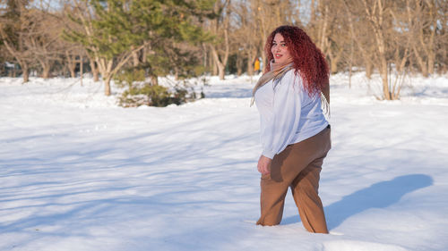 Young woman standing on snow covered field