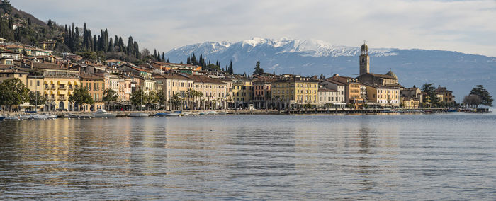 Extra wide view the beautiful lakeside of salò with the lake garda and the monte baldo in background