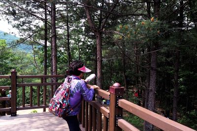 Rear view of woman standing on footbridge