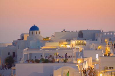 Illuminated buildings against sky during sunset in city