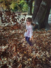 Full length of girl with autumn leaves