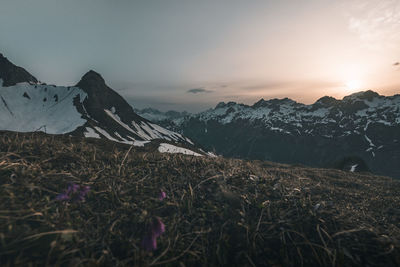 Scenic view of snowcapped mountains against sky during sunset