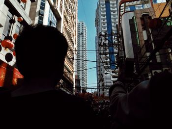 Rear view of man and woman against buildings in city