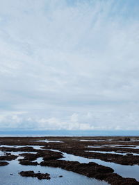 Scenic view of snow covered land against sky