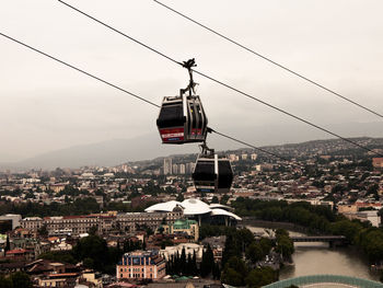 High angle view of overhead cable car by buildings against sky