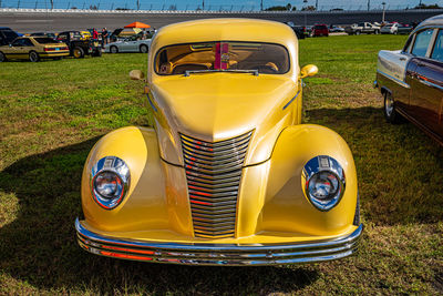 Close-up of yellow car parked on field