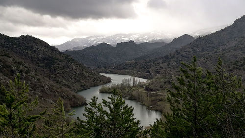 Scenic view of river amidst mountains against sky