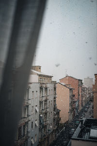 Buildings seen through window during rainy season