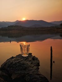 Scenic view of lake against mountain during sunset