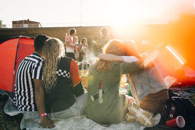 Rear view of friends sitting together while watching music concert